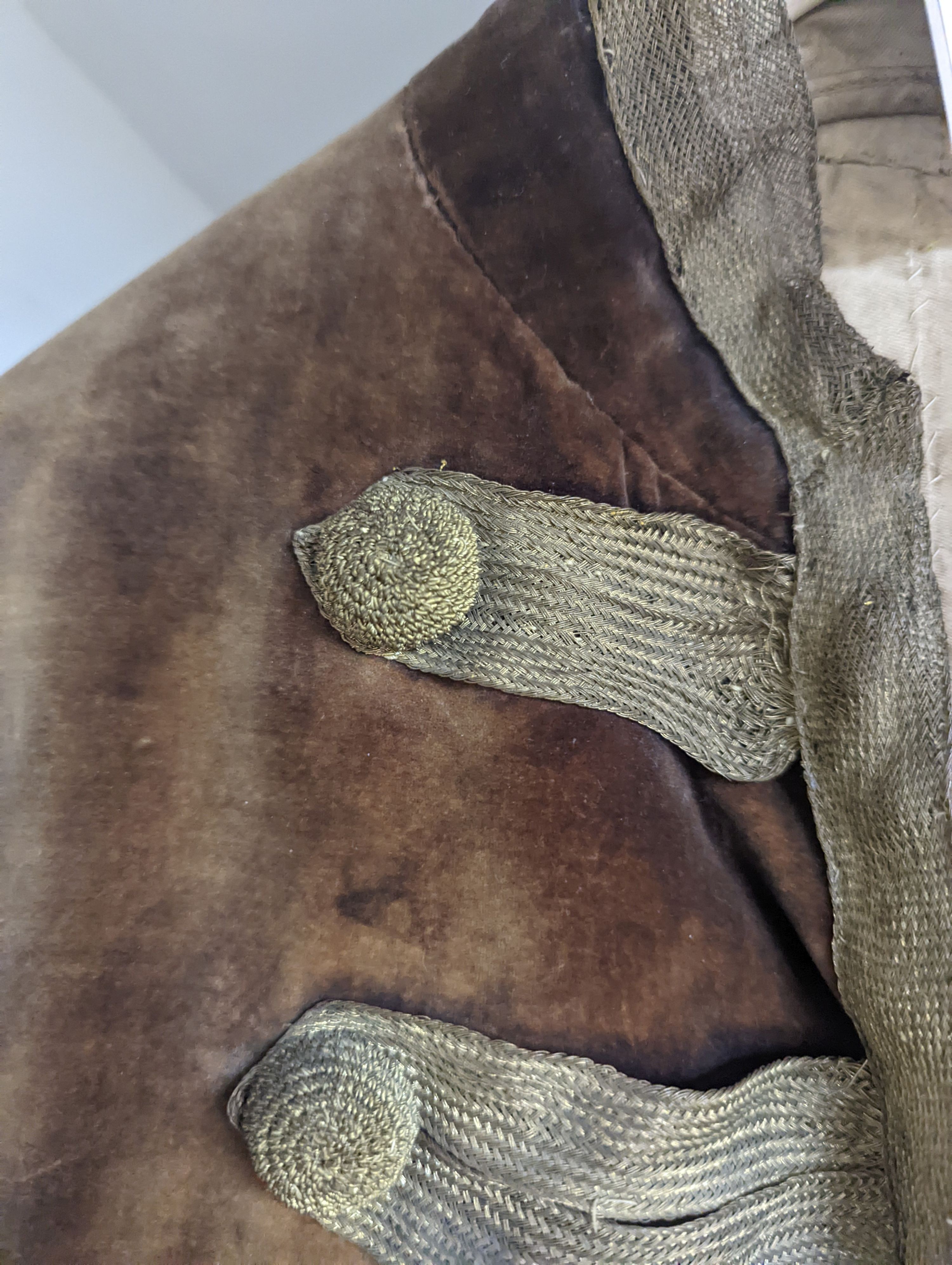 A Georgian gents cream damask waistcoat, a similar waistcoat with beading applied later and a velvet and gold braided tailcoat